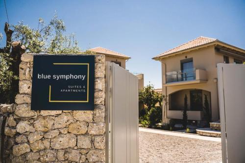 a sign on a stone wall in front of a house at blue symphony suites apartments in Nikiana