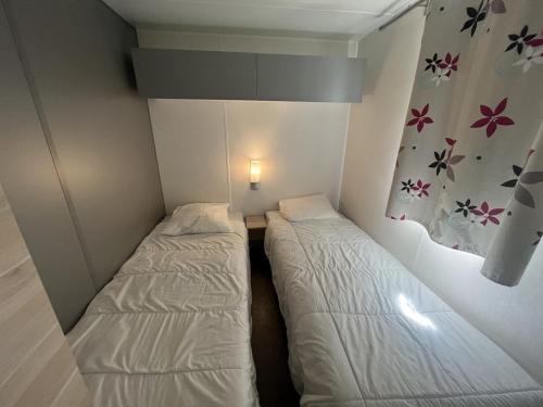 a small room with two beds and a light on the wall at Camping Prima in Týn nad Vltavou