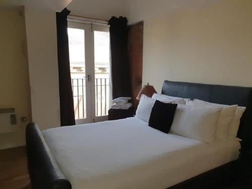 Schlafzimmer mit einem großen weißen Bett und einem Fenster in der Unterkunft Infinity Partypadsliverpool Hen And Stag Welcome in Liverpool