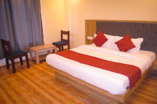 a bedroom with a large bed and two chairs at The Fragrance Hotel in Katra