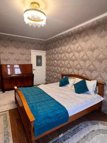 een slaapkamer met een bed en een kroonluchter bij Apartment on Jeltoksan in Simkent