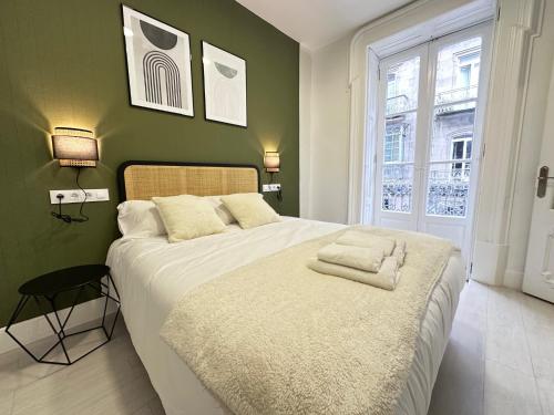 um quarto com uma grande cama branca e uma janela em Elegante hogar en el centro em Vigo