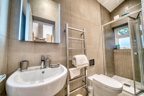 La salle de bains est pourvue d'un lavabo, de toilettes et d'une douche. dans l'établissement Luxury Terraced Victorian House, à Londres