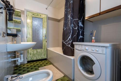 een badkamer met een wasmachine en een wastafel bij Vision Apartment - Livigno in Livigno