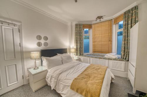 a bedroom with a large bed and a window at Luxury Terraced Victorian House in London