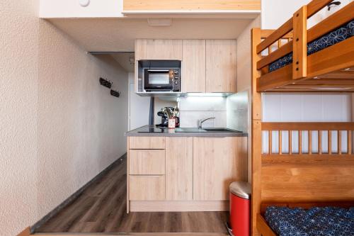 une petite cuisine avec un évier et un micro-ondes dans l'établissement L'Etoile Polaire - Appt vue montagne, à Villarembert