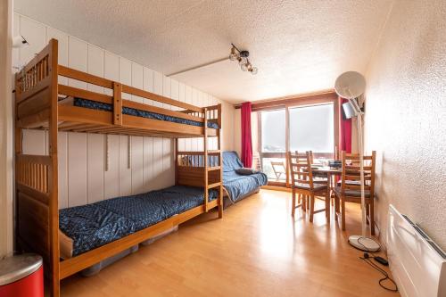 une chambre avec des lits superposés et une salle à manger avec une table dans l'établissement L'Etoile Polaire - Appt vue montagne, à Villarembert