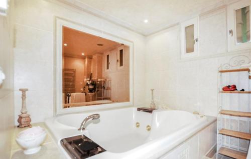 La salle de bains blanche est pourvue d'une baignoire et de toilettes. dans l'établissement Charming villa with pool, sea and mountain views, à Argelès-sur-Mer