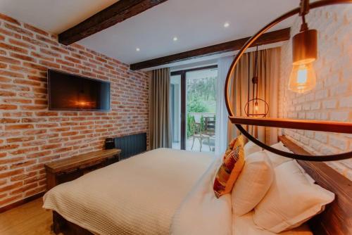 ein Schlafzimmer mit einem Bett und einer Ziegelwand in der Unterkunft The Owl's Nest 2 in Welingrad
