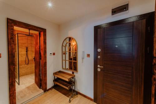 a hallway with a wooden door and a mirror at The Owl's Nest 2 in Velingrad