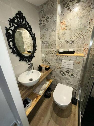 une salle de bain avec un lavabo, des toilettes et un miroir dans l'établissement Chez Bardot, au Puy-en-Velay