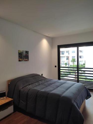 a bedroom with a large bed and a large window at Duplex One Hill Ville Verte M in Casablanca
