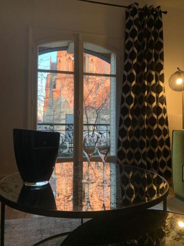 Cette chambre dispose d'une fenêtre et d'une table avec des verres à vin. dans l'établissement By Le PARVIS, à Reims