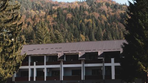 a building in front of a mountain with trees at Hotel Muška voda in Kladanj