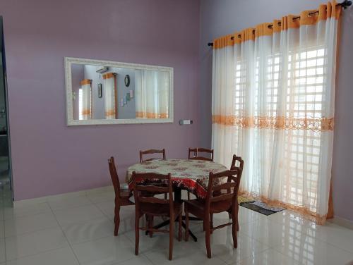 Kampong Batu DuaにあるMysa Homestayのダイニングルーム(テーブル、椅子、鏡付)