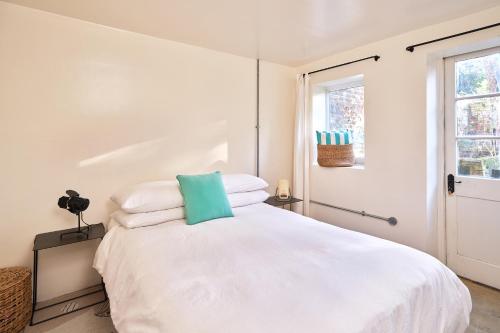 a bedroom with a white bed with white pillows at Unique Georgian Garden Flat in Central Margate in Margate