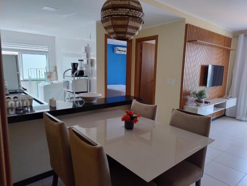 comedor con mesa blanca y sillas en Prainha Aconchegante apto de quarto e sala com vista para o mar en Arraial do Cabo