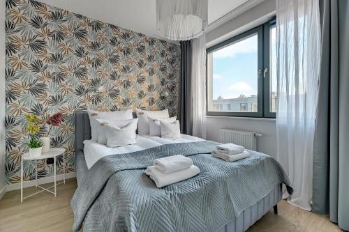 1 dormitorio con 1 cama con toallas en Downtown Apartments City Center SCALA en Gdansk
