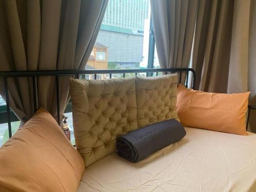 a bed with pillows sitting in front of a window at Urban Oasis Retreat in Melaka