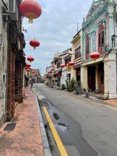 an empty street with red lanterns hanging from buildings at Urban Oasis Retreat in Melaka