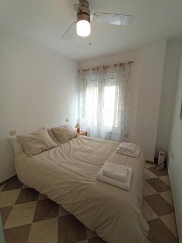 1 dormitorio con 1 cama grande y 2 toallas. en Apartamento Urba Ruta del Veleta, en Cenes de la Vega