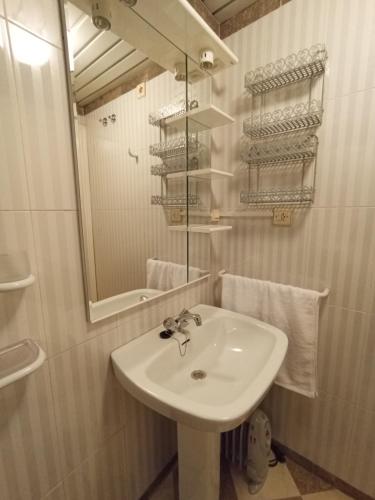 y baño con lavabo, espejo y toallas. en Apartamento Urba Ruta del Veleta, en Cenes de la Vega
