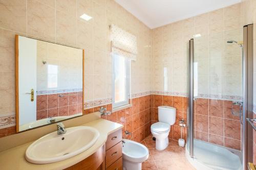 a bathroom with a sink and a toilet and a shower at Villa alhabu in Albufeira