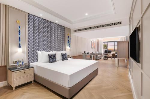 um quarto com uma grande cama branca e uma sala de estar em Antarim Resort em Candolim