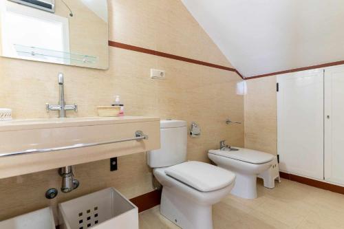 La salle de bains est pourvue de toilettes blanches et d'un lavabo. dans l'établissement rentafive Nuevo AA Reformado Piscina, à Gran Alacant