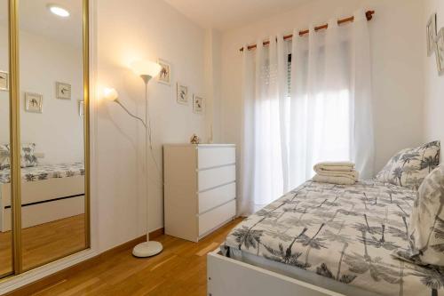- une chambre avec un lit, une commode et un miroir dans l'établissement rentafive Nuevo AA Reformado Piscina, à Gran Alacant