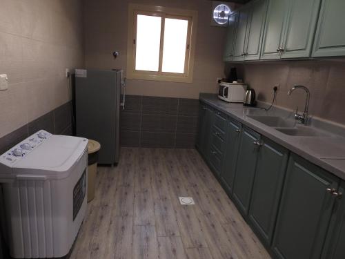 a small kitchen with a sink and a refrigerator at نيو العرين بارك أبها in Abha