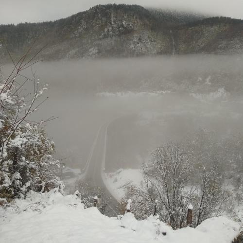 a misty lake in the middle of a snowy mountain at Family owned self sufficient ECO farm TARA in Pljevlja