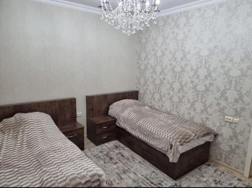 um quarto com 2 camas e um lustre em Beautiful Villa em Qusar