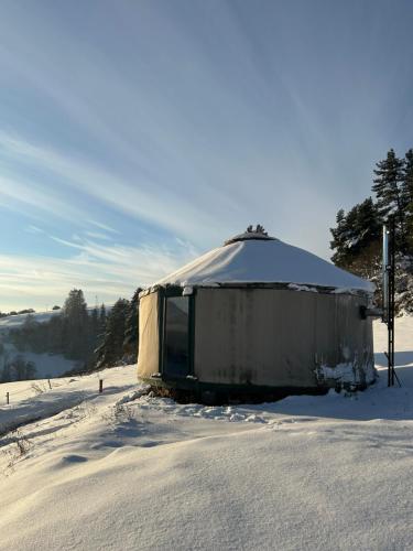 a yurt is covered in snow in a field at Dzikość Serca - Jurta z widokiem na Tatry in Knurów