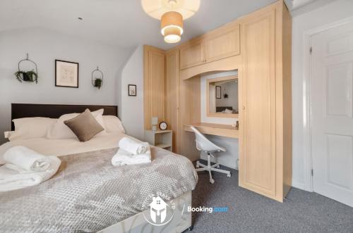 a bedroom with a bed and a desk with a chair at Charming Cosy 3 Bed Flat In City Centre I Free WiFi I Free Parking I Work Desks I NetflixI in Leicester