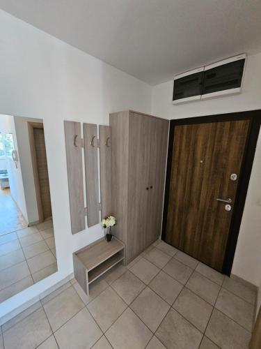 a bathroom with a wooden door and a vase of flowers at EApartments in Skopje