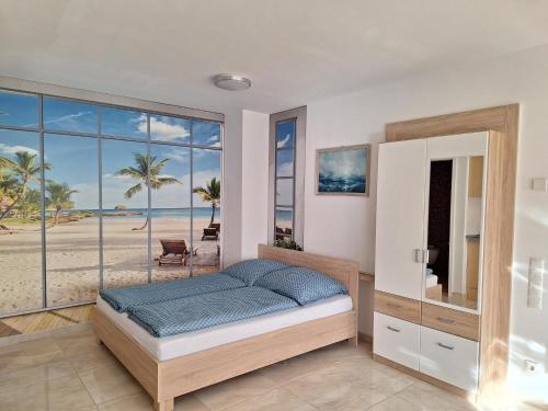 um quarto com uma cama e vista para a praia em Casa Blanca em Wirges