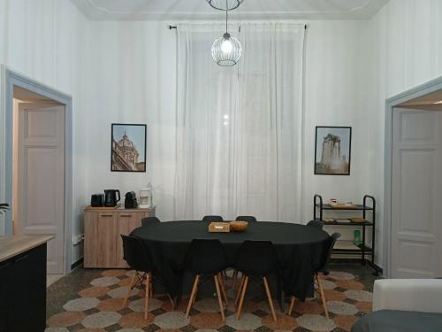 une salle à manger avec une table et des chaises noires dans l'établissement Rome - Termini House, à Rome