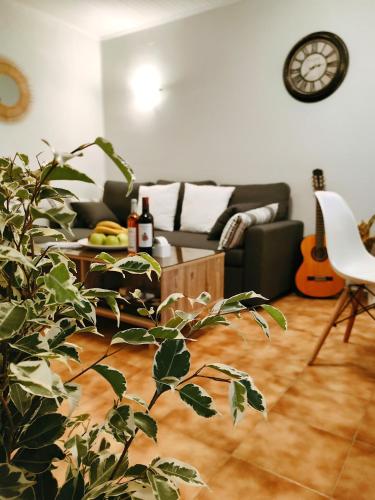 a living room with a couch and a clock on the wall at Zika's House in Kanálion