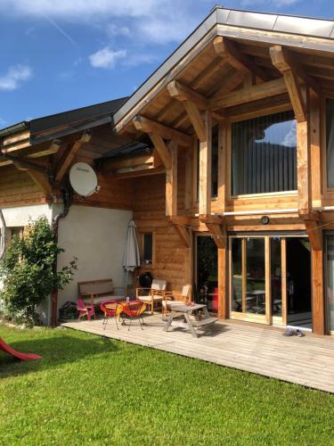 Casa de madera grande con patio y césped en Chalet La Merlerie en Morzine