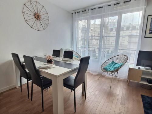 une salle à manger avec une table, des chaises et une télévision dans l'établissement Le Nuage d'Arianne*Vale d'Europe *Disney*Paris, à Chessy