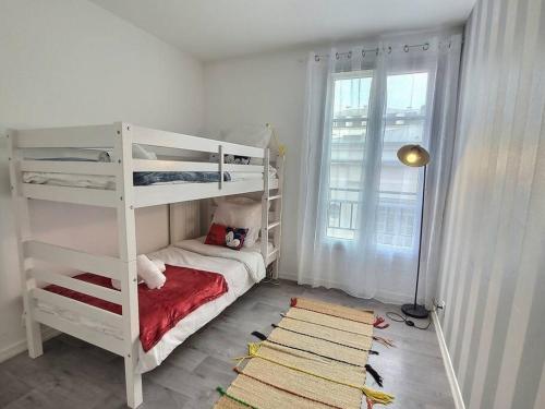 Ce lit superposé blanc se trouve dans un dortoir doté d'une fenêtre. dans l'établissement Le Nuage d'Arianne*Vale d'Europe *Disney*Paris, à Chessy