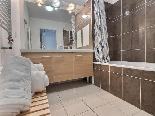 une salle de bain avec une baignoire, un lavabo et un miroir dans l'établissement Le Nuage d'Arianne*Vale d'Europe *Disney*Paris, à Chessy