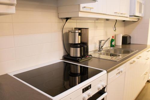 Lahti Furn House في لاهتي: مطبخ مع آلة صنع القهوة ومغسلة