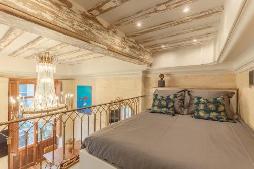 Schlafzimmer mit einem Bett und einem Kronleuchter in der Unterkunft LA Sainte Catherine 215 - Place de Parking in Bordeaux