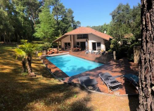 une piscine devant une maison dans l'établissement Villa avec piscine pétanque ping-pong garage près golf plage, à Moliets-et-Maa