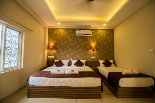 a bedroom with two beds and a wall at Oak Field Inn in Cochin