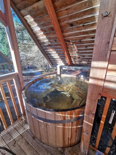 a hot tub on a deck with a roof at Ribno Alpine Glamping in Bled