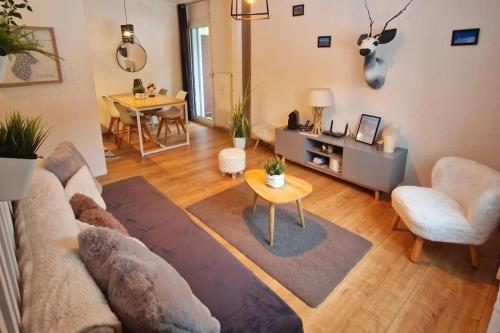 a living room with a couch and a table at Studio au cœur des Alpes et Parking gratuit in Crans-Montana