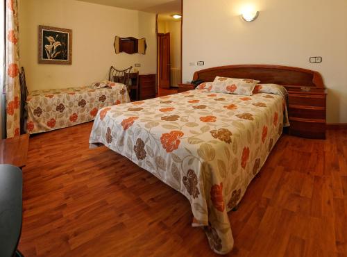 a bedroom with a bed and a wooden floor at Hotel Piedra in Perlora